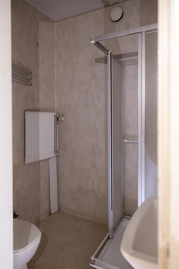 Vy över duschen i badrummet hos Pulsen Fastigheter innan renovering